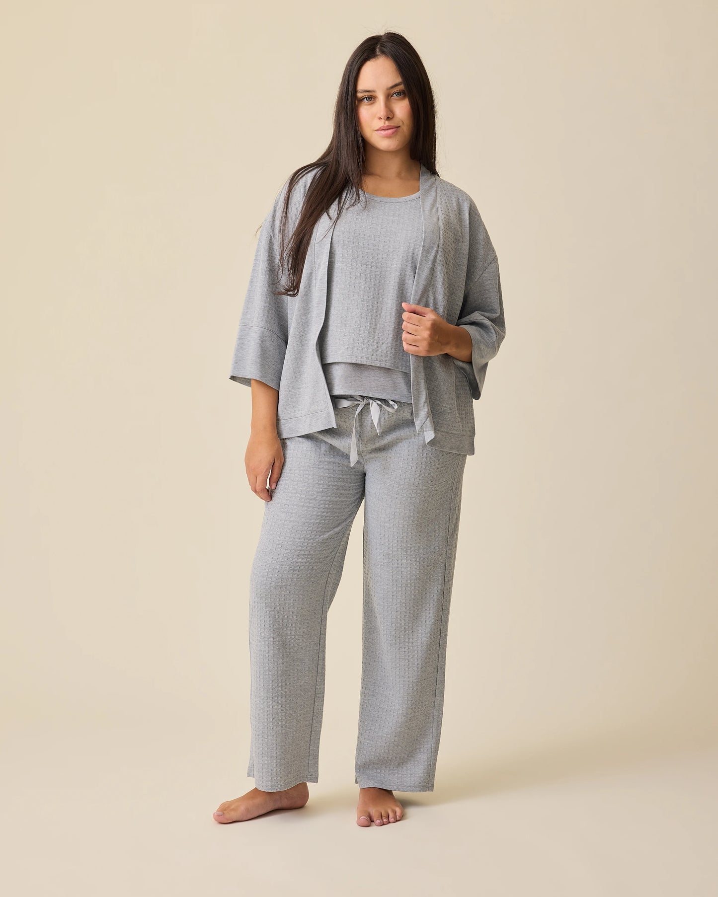 Model is wearing the Waffle Maternity & Nursing Three-Piece Lounge Set in Grey Heather on a beige background. @model_info:Brianna is 5'8" and wearing a Medium.