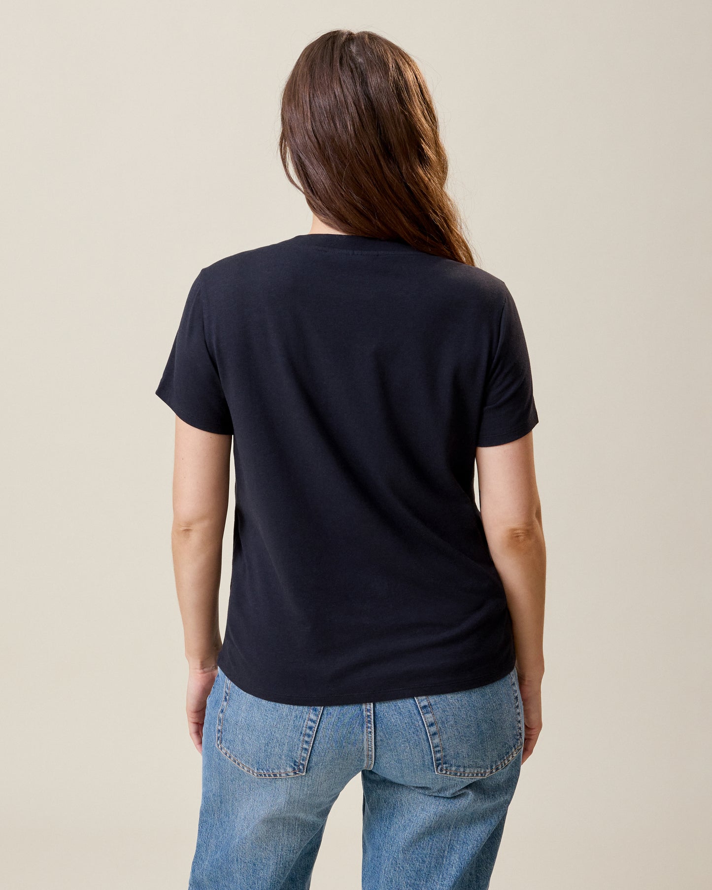 Back view of model wearing Classic Modal V-neck Nursing T-shirt in Black on a neutral background