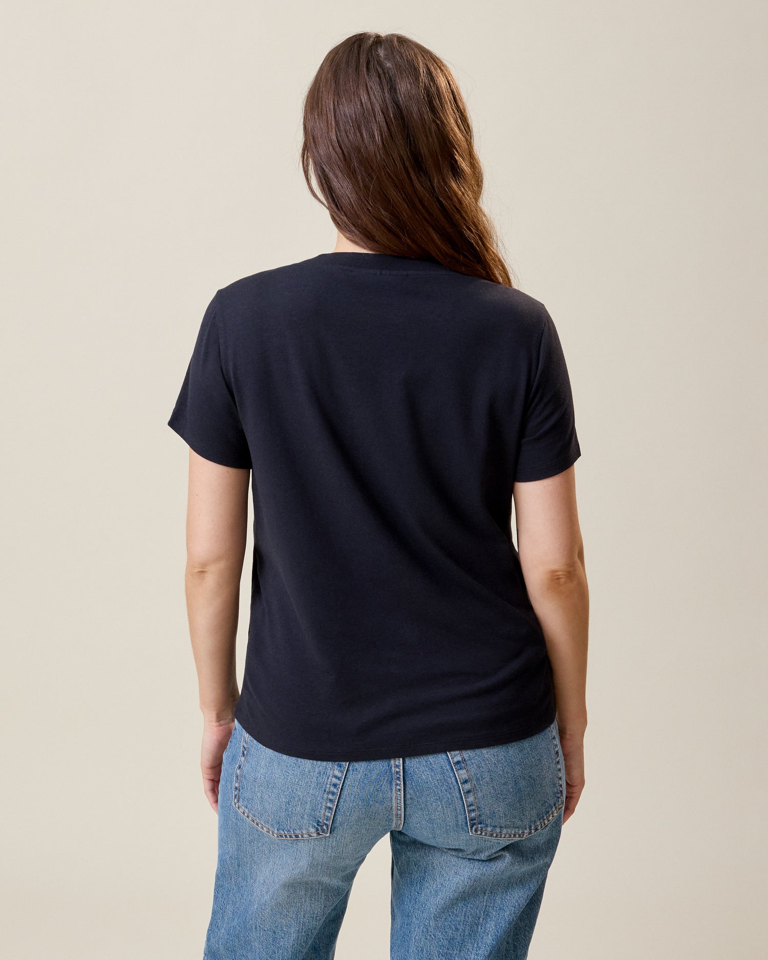 Back view of model wearing Classic Modal V-neck Nursing T-shirt in Black on a neutral background