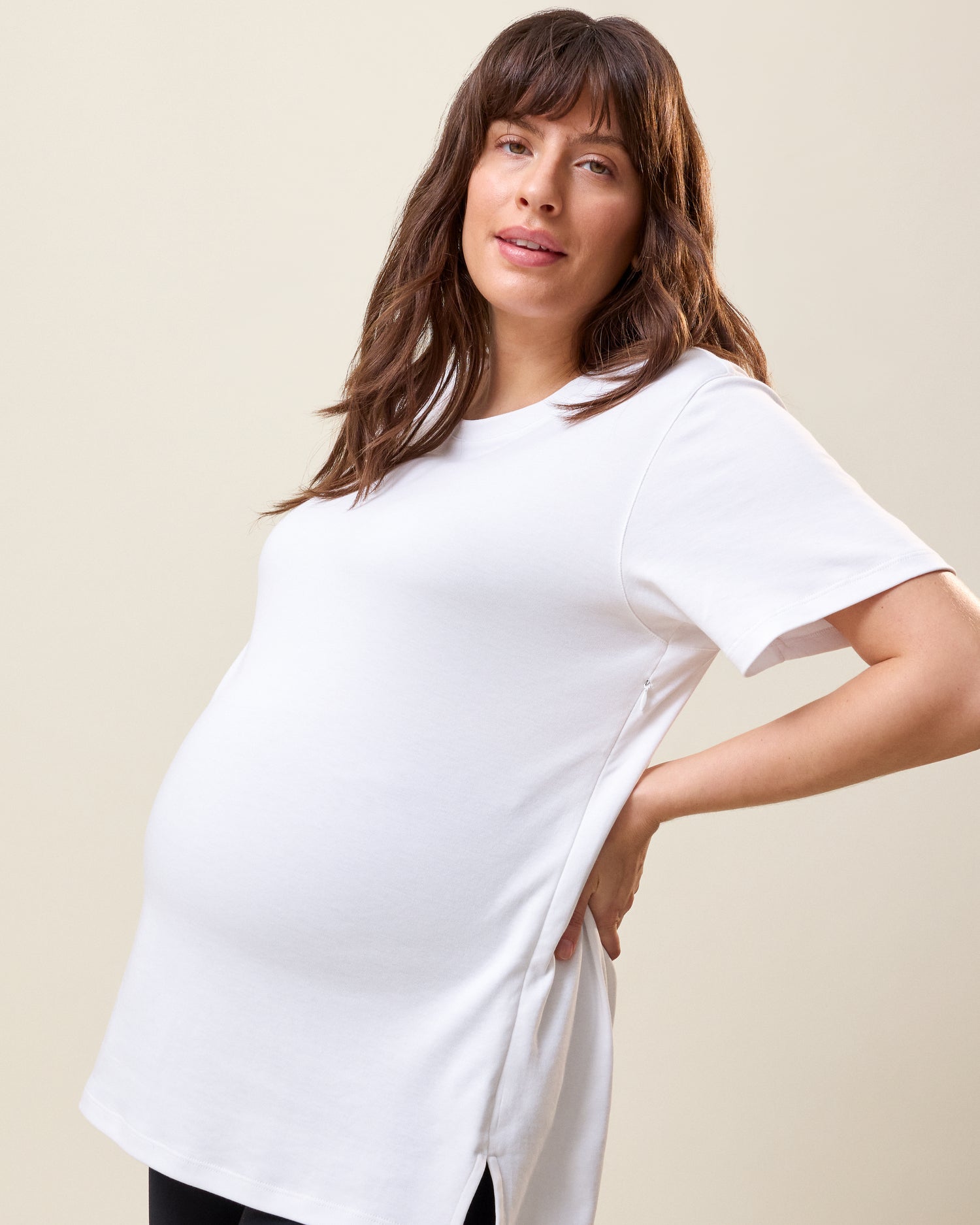 Side view of model wearing Pima Cotton Side Zip Maternity & Nursing T-shirt in White on a neutral background