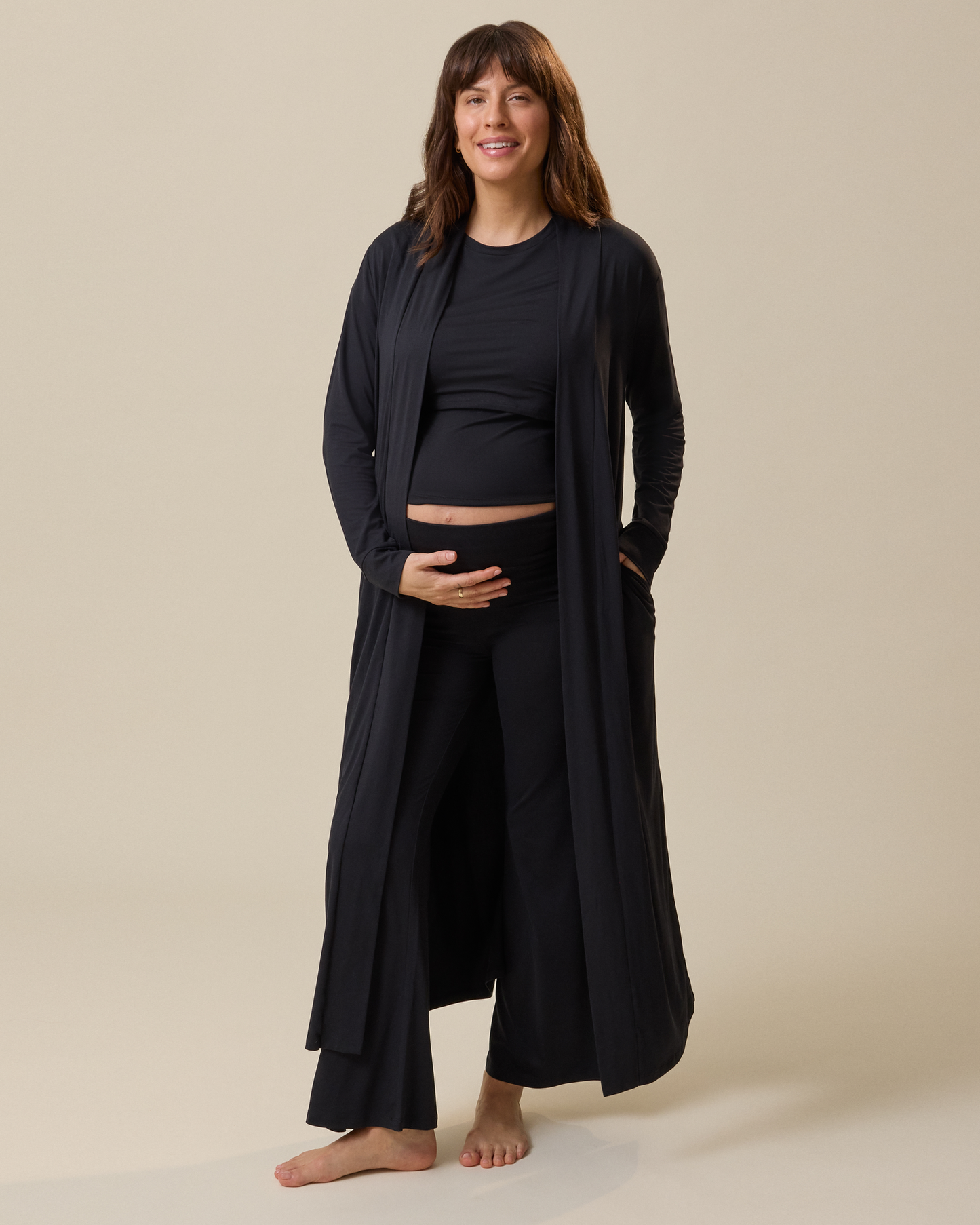 Woman wearing a black lounge outfit with a long cardigan on a beige background@model_info:KJ is 5'9" and wearing a Medium.