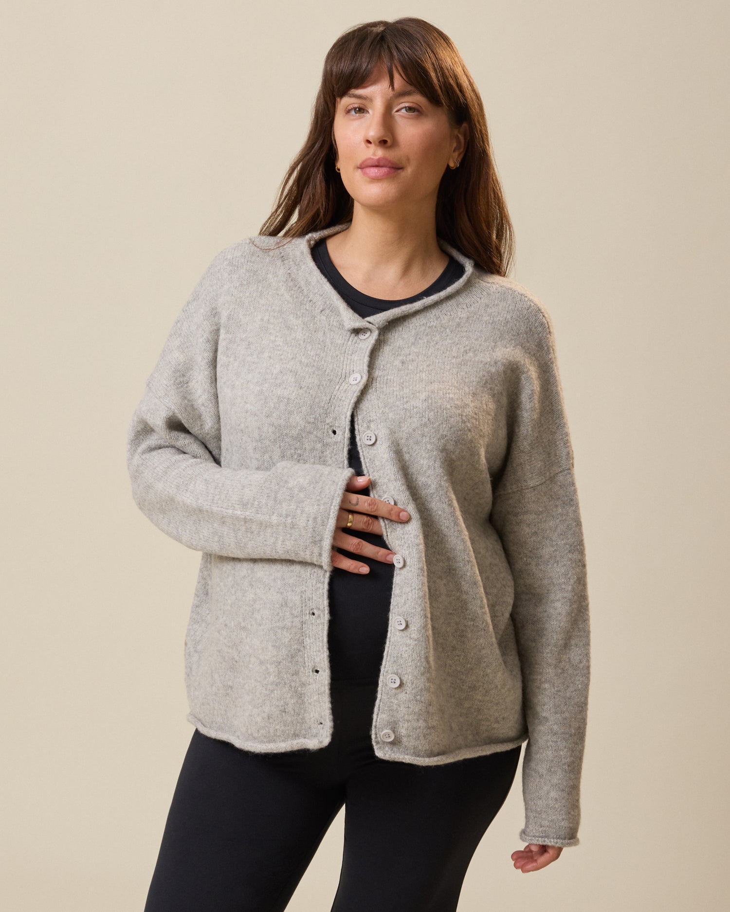 Woman wearing a gray cardigan against a beige background@model_info:KJ is wearing a Medium.