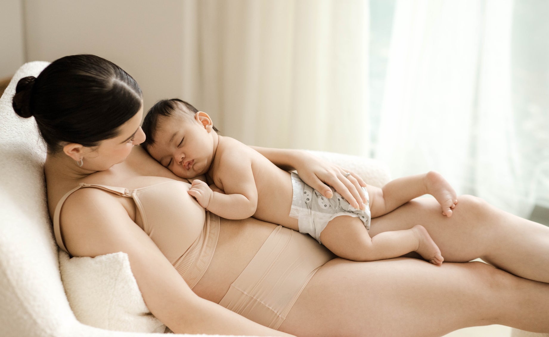 Mother cuddling her baby after breastfeeding