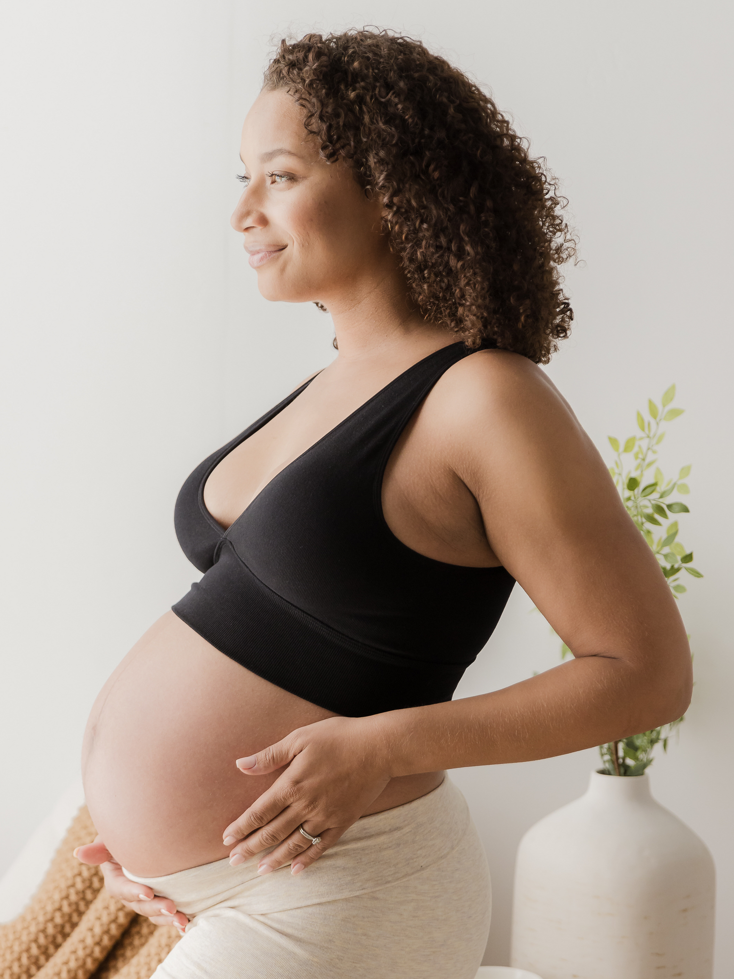 Pregnant model wearing the Sublime Bamboo Maternity & Nursing Plunge Bra in black paired with the Sublime Bamboo Bike Shorts in Oatmeal Heather.