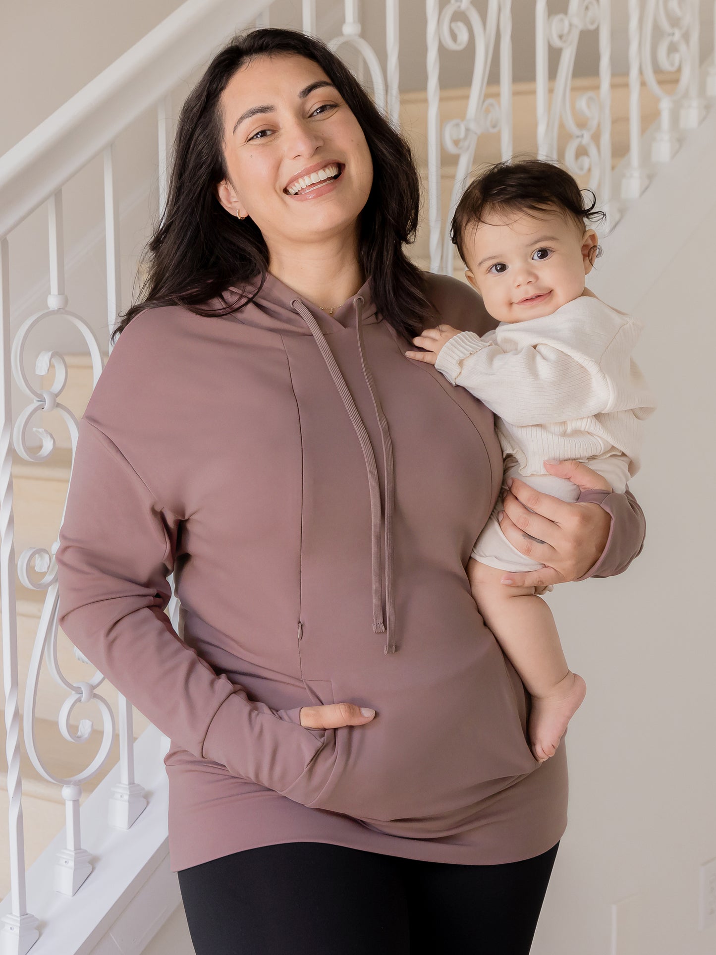 Front view of model wearing the Bamboo Maternity & Nursing Hoodie in Twilight, and holding baby@model_info:Connie is wearing an X-Large.