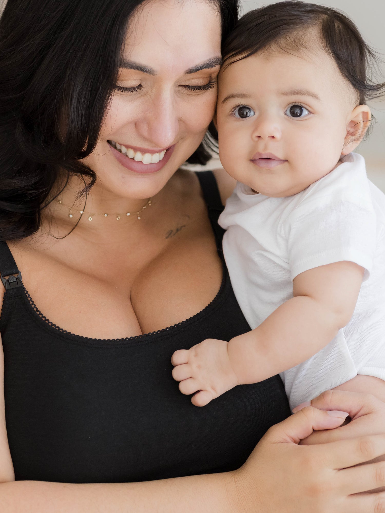 Close up image of model holding baby and wearing the Picot Trim Nursing Camisole in black, highlighting the trim detail @model_info:Connie is wearing an X-Large.