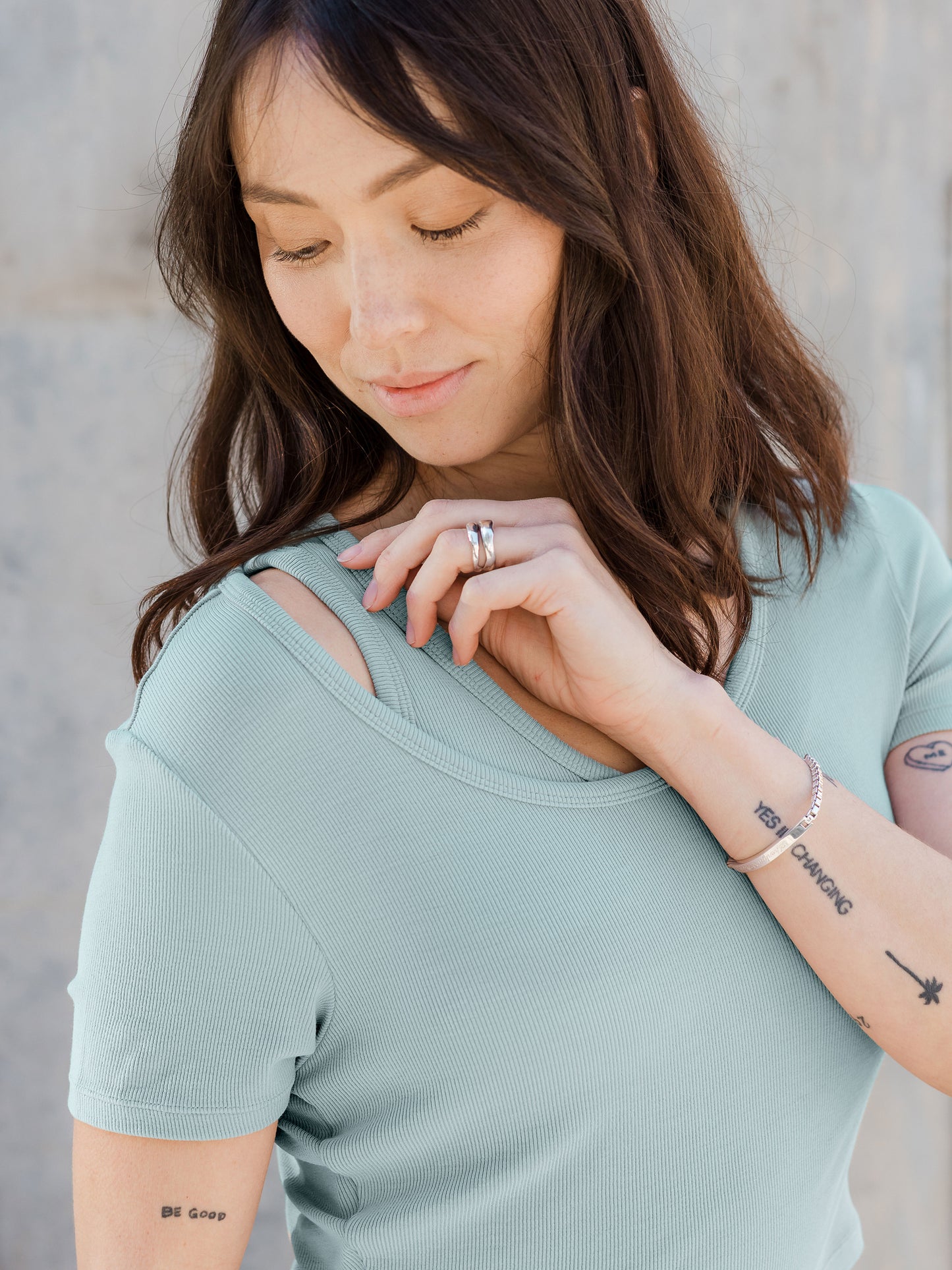 Model is wearing the Olivia Ribbed Bamboo 2-in-1 Maternity & Nursing Dress in Dusty Blue Green, showing off the tank top straps of the dress.