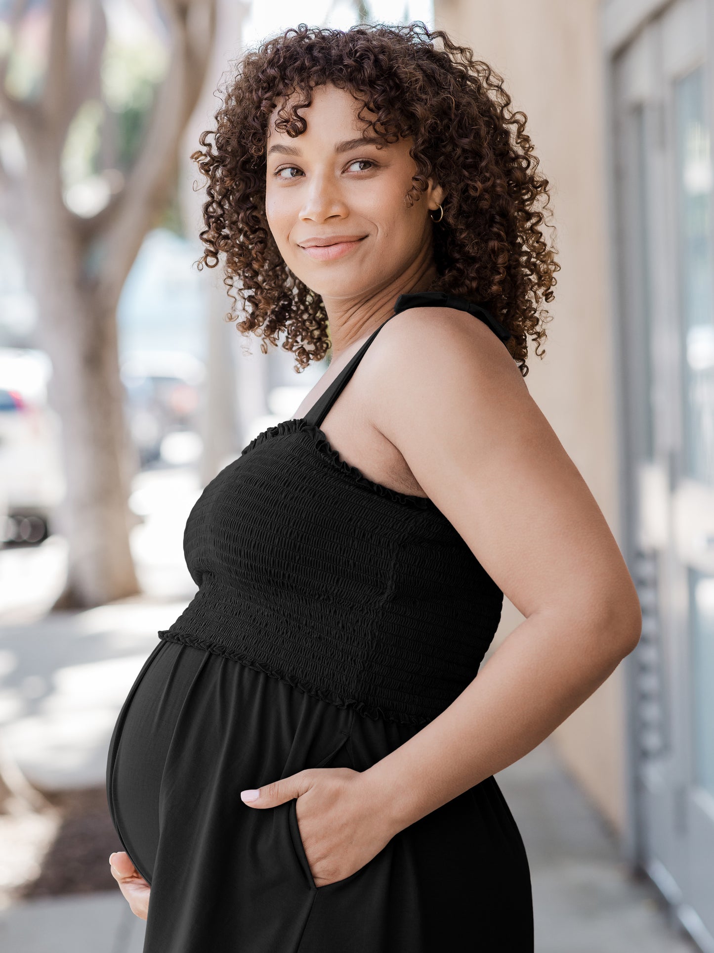 Pregnant model wearing the Sienna Smocked Maternity & Nursing Dress in black