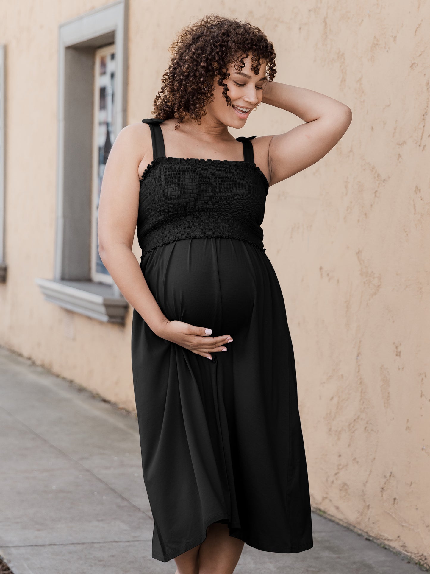 Pregnant model wearing the Sienna Smocked Maternity & Nursing Dress - black@model_info:Alysha is 5'6" and wearing a Large.
