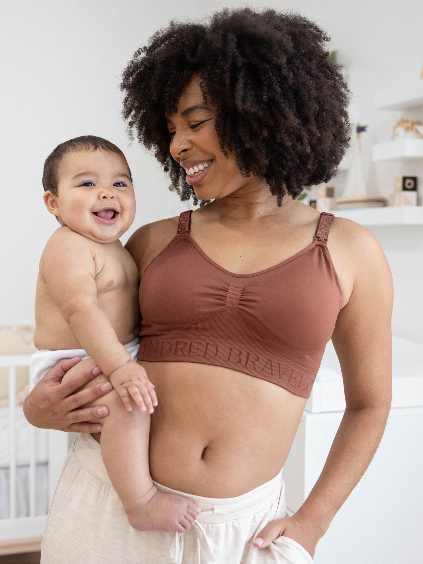 Model holding her baby while wearing the Simply Sublime® Nursing Bra in redwood