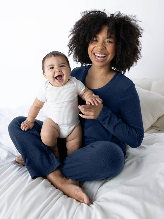 Model sitting with her baby wearing the Fleece Nursing & Maternity Pajama Set in Navy. @model_info:Tess is wearing a Small.