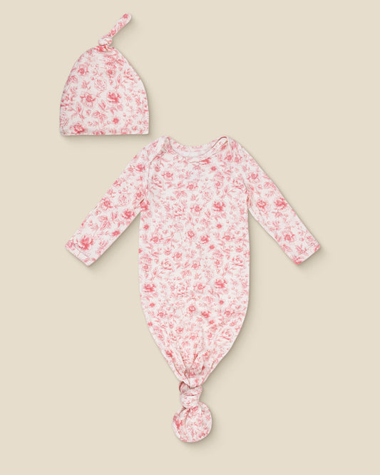 Floral Bamboo Knotted Baby Gown & Hat in pink toile with long-sleeve knotted top and matching hat on a beige background