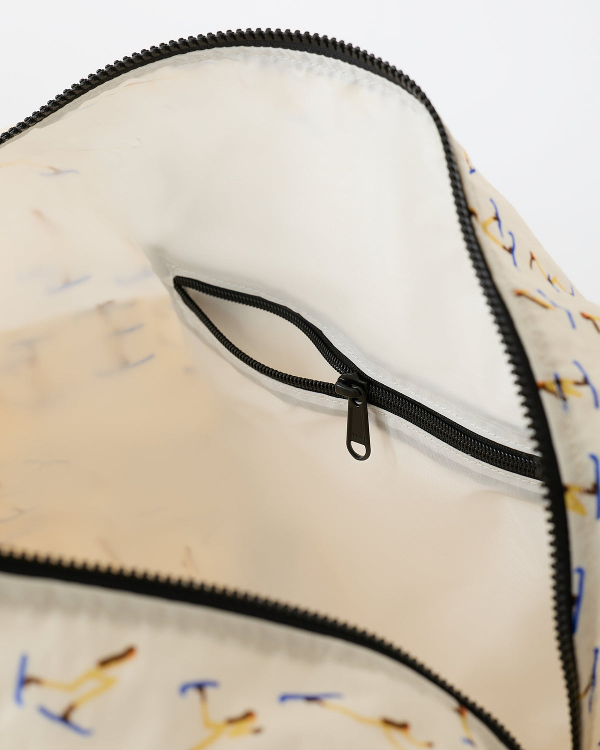 Close up on the interior and zippers, on the Large Weekender Bag in Ivory Ski, on an off white background.