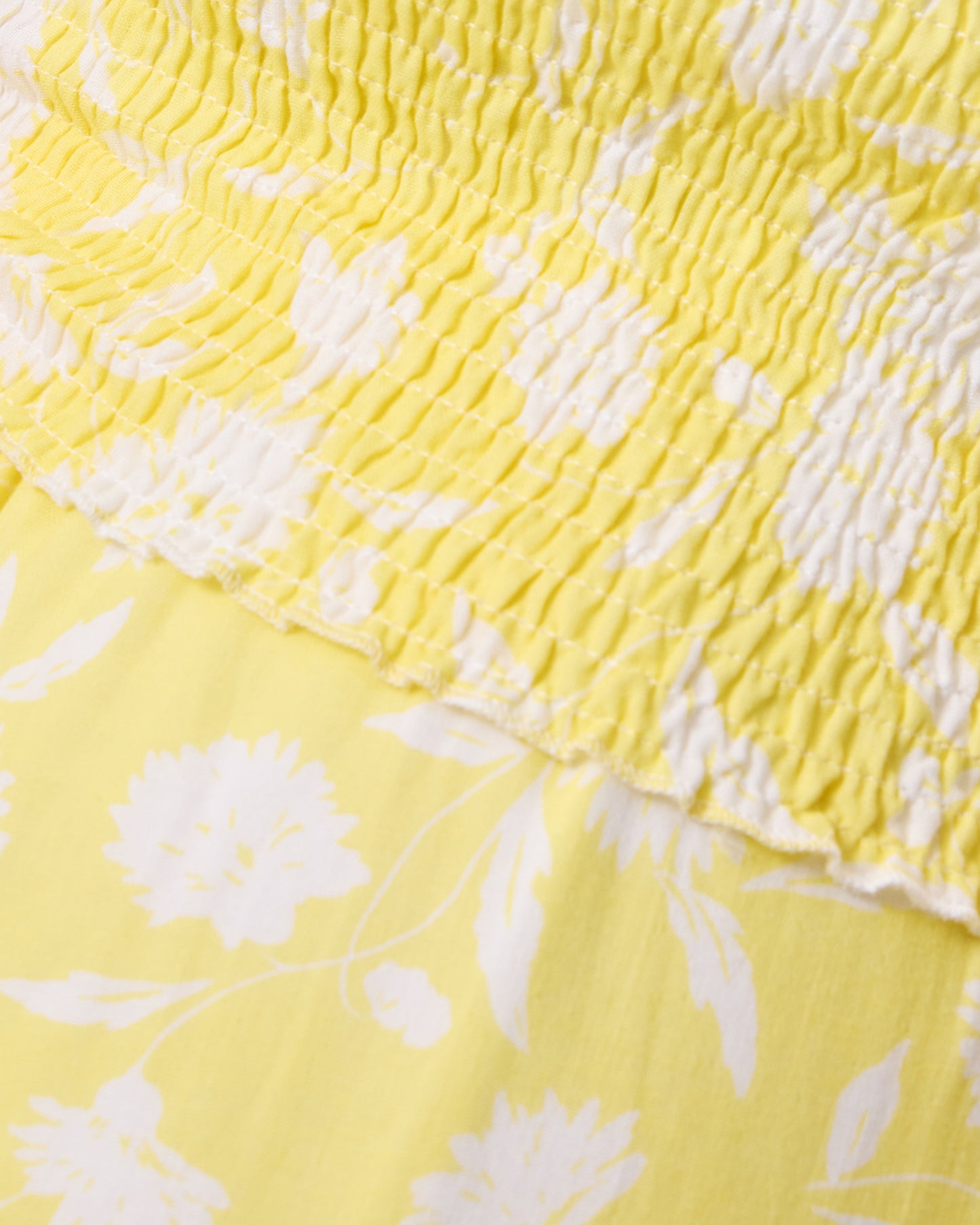 Close-up of yellow and white fabric with white floral pattern and rouching detail