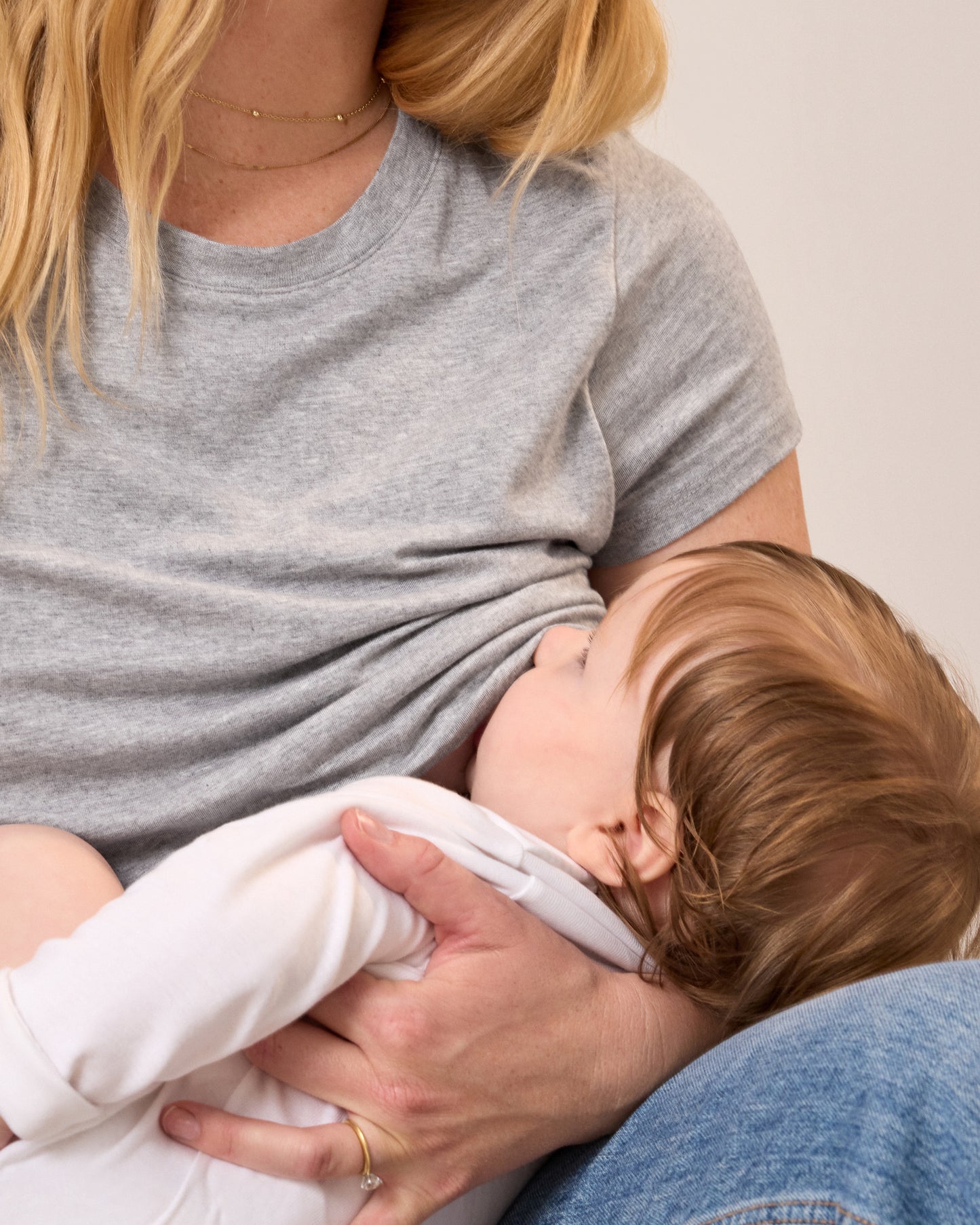 Model wearing the Slim Fit Modal Nursing T-shirt in Grey Heather nursing a baby