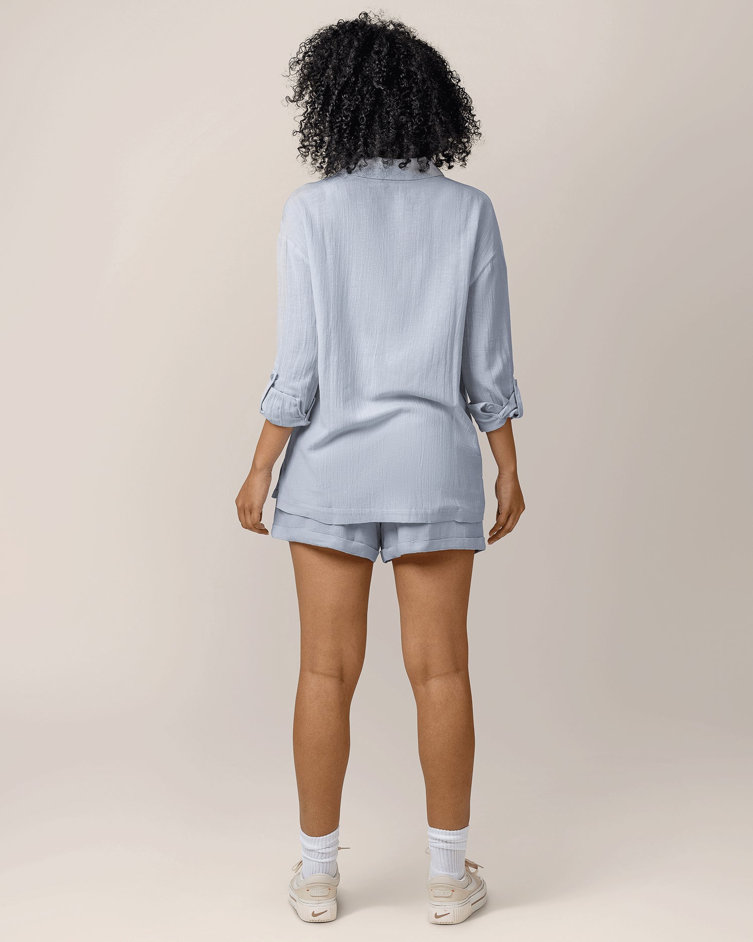 Back view of model wearing the Reese Oversized Linen Button Down Shirt in French Blue, paired with matching Reese Linen Short