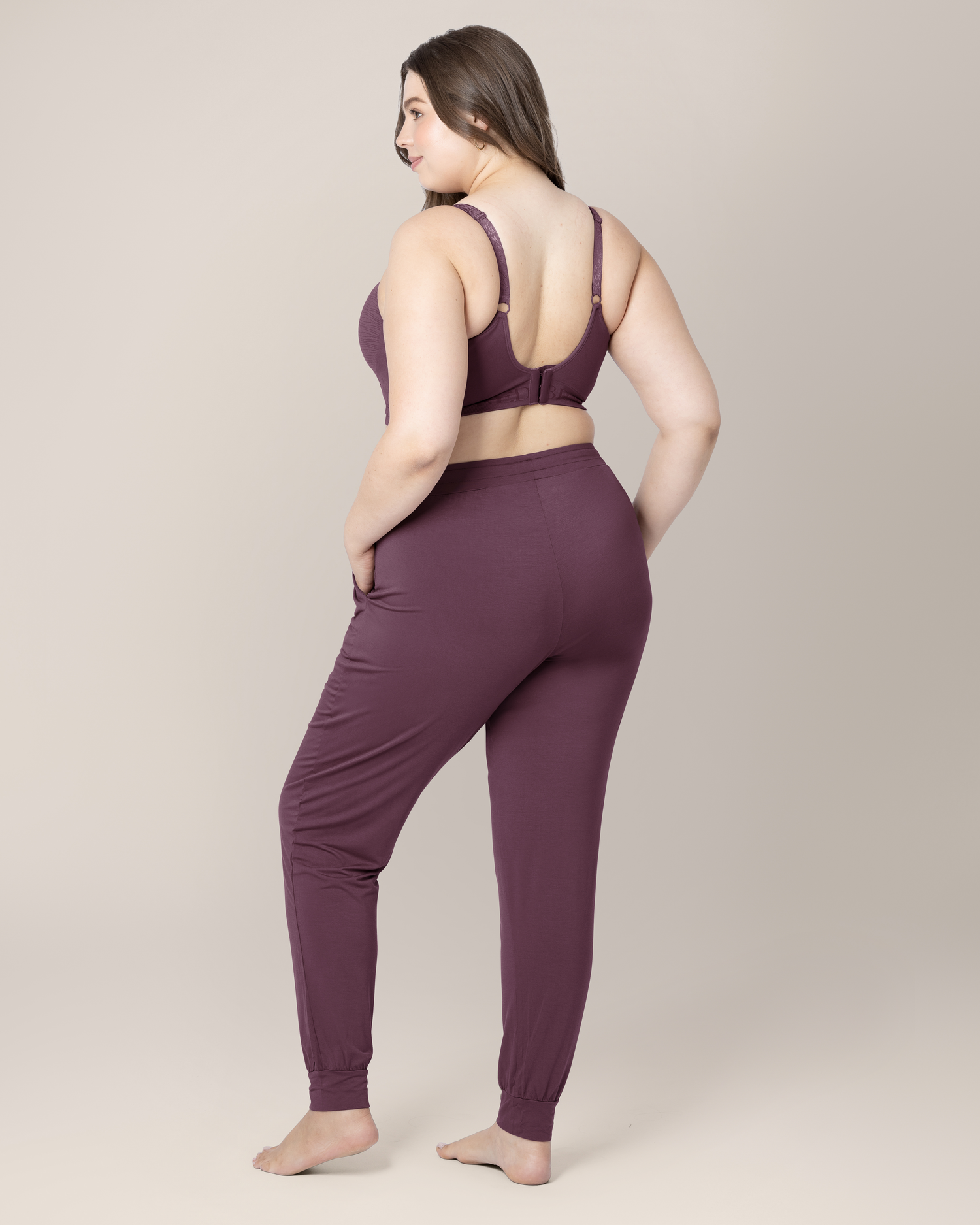 3/4 back view of model wearing the Everyday Lounge Jogger in Burgundy Plum, paired with matching Sublime® Hands-Free Pumping & Nursing Bra