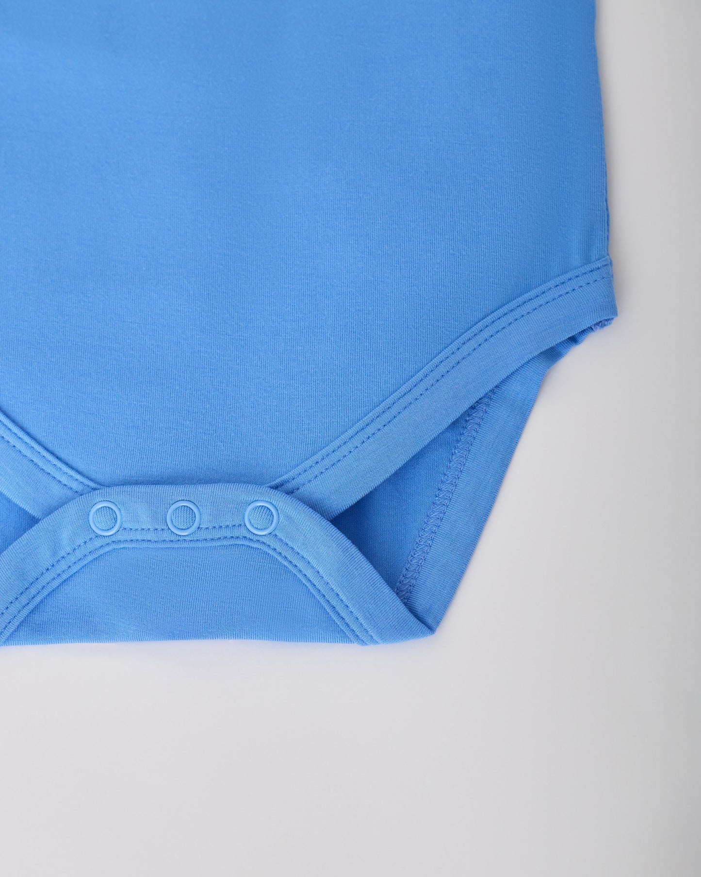 Close up of snaps on Blue Bird in the Long Sleeve Bamboo Onesie Two-Pack in Bird on a white background.