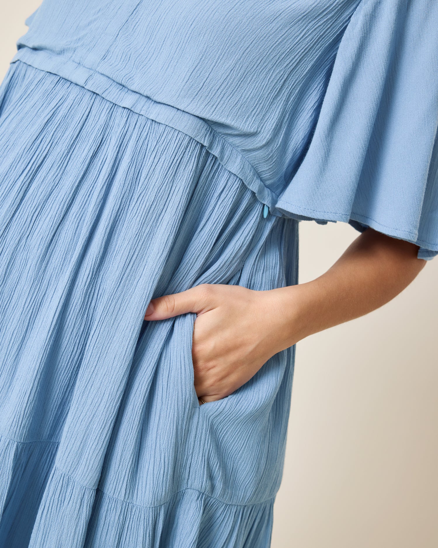 Close up of model wearing Marlowe Maternity & Nursing Mini Dress in Vintage Blue with the hand placed on the dress's pocket