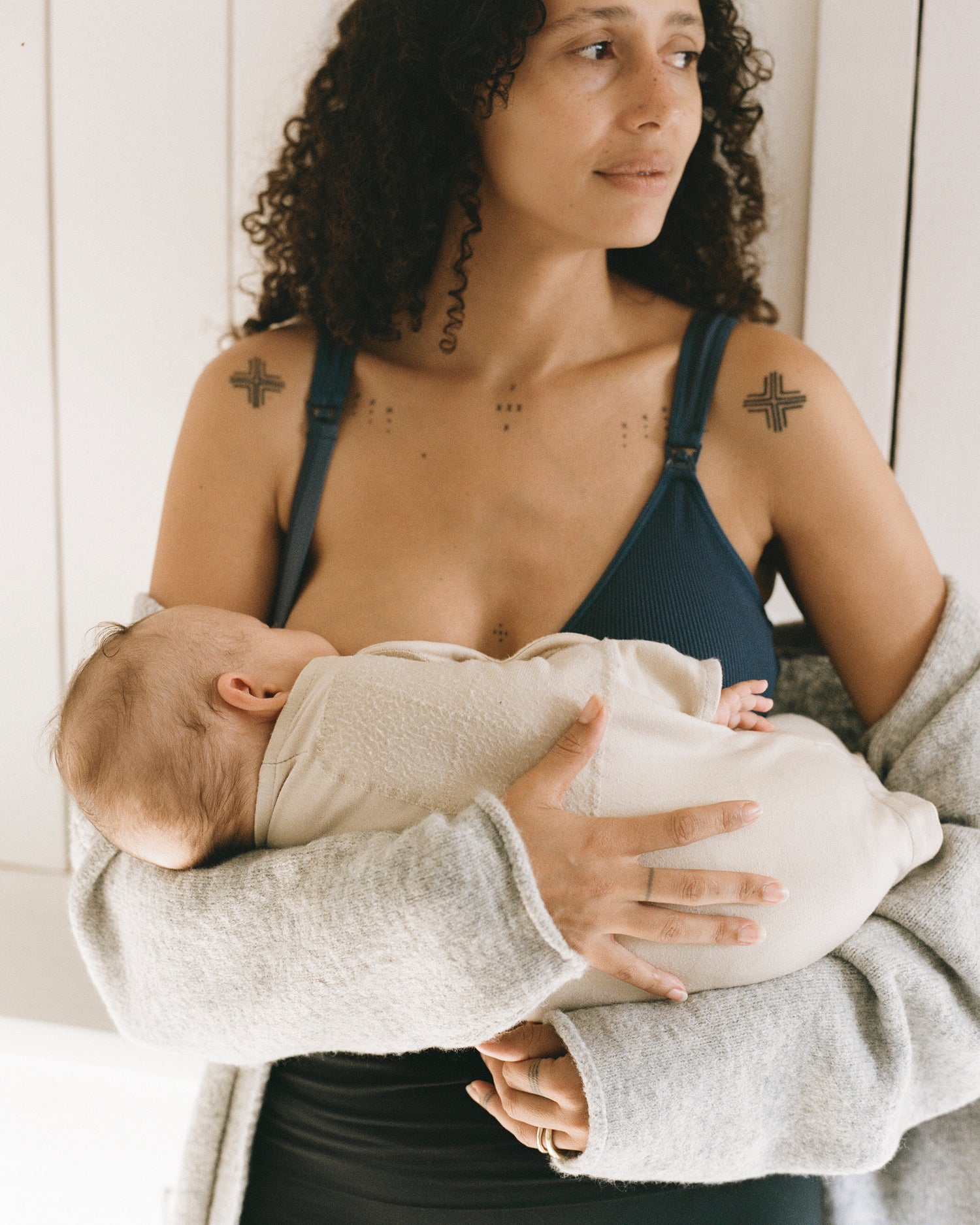 Model wearing Mia Maternity & Nursing Lounge Bra in Light Navy while a baby nurses  @model_info:Natasha is wearing a Medium.