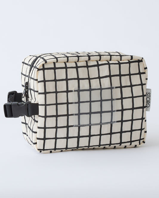 Mini Cooler Bag in Black Grid, on a beige background.