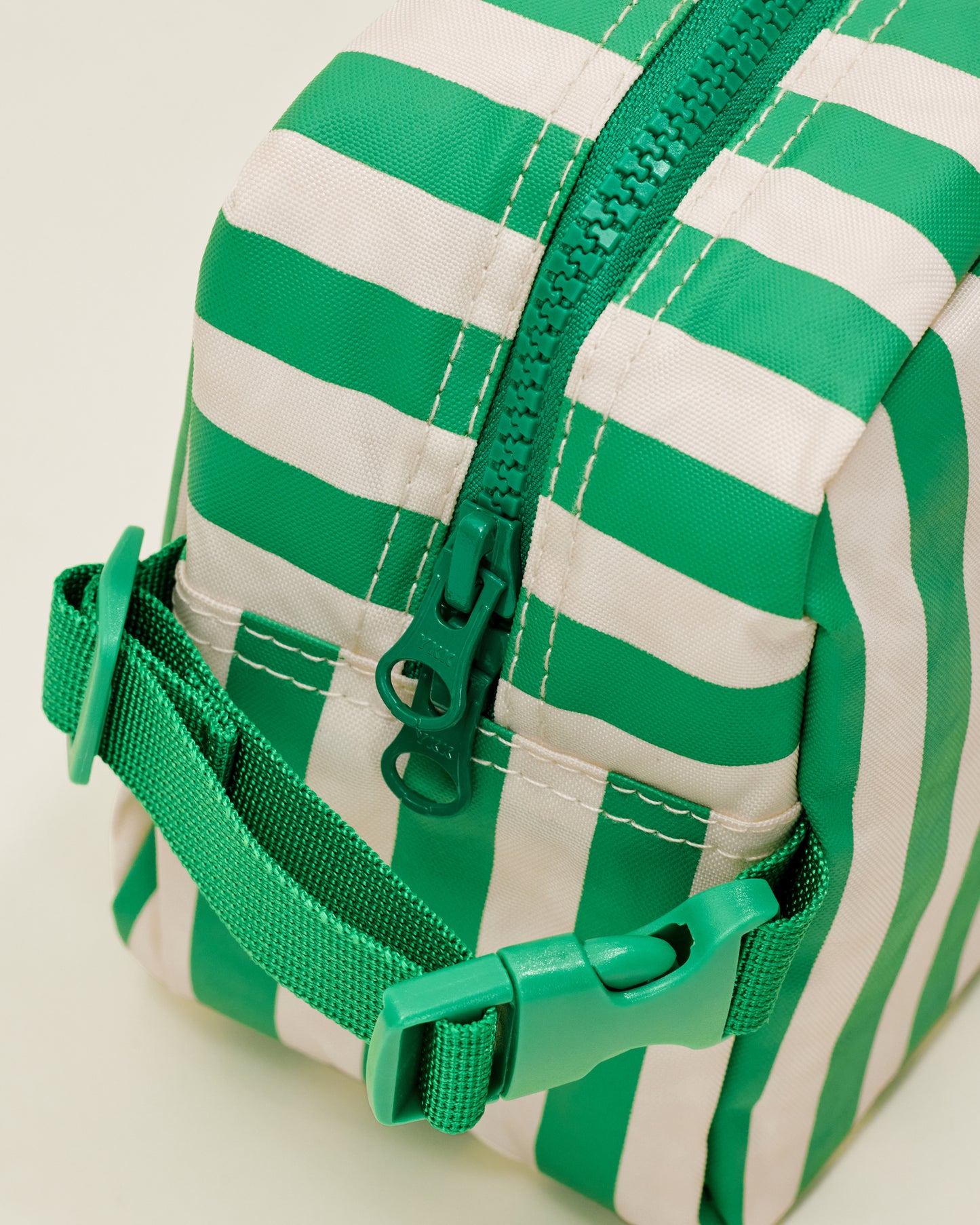 Close up of the Mini Cooler Bag in the Green Stripe print, showing a detail of a handle with a clasp