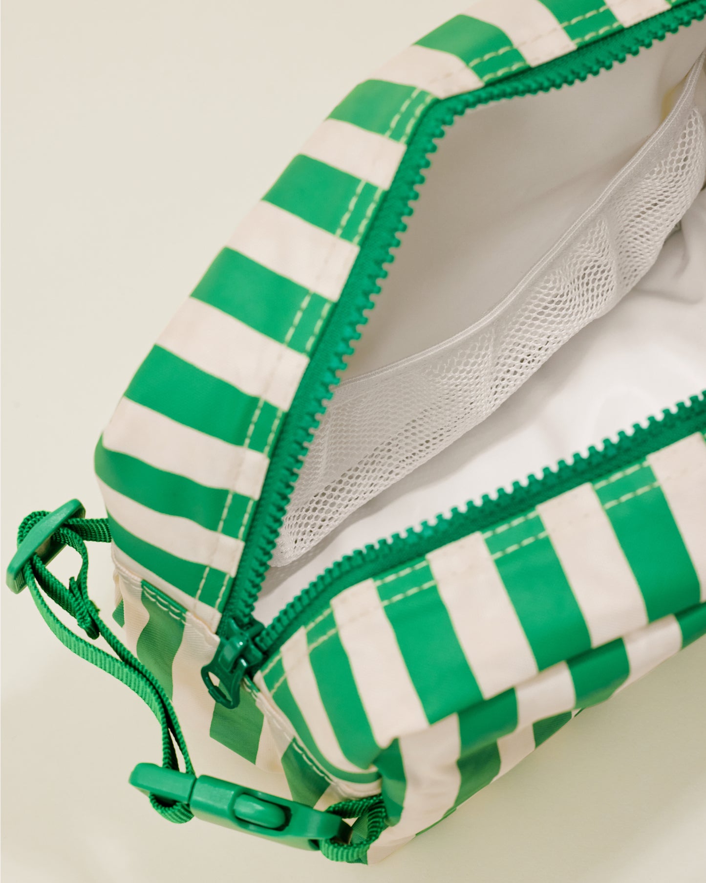 Close up of the Mini Cooler Bag in the Green Stripe print, showing a mesh compartment inside the bag