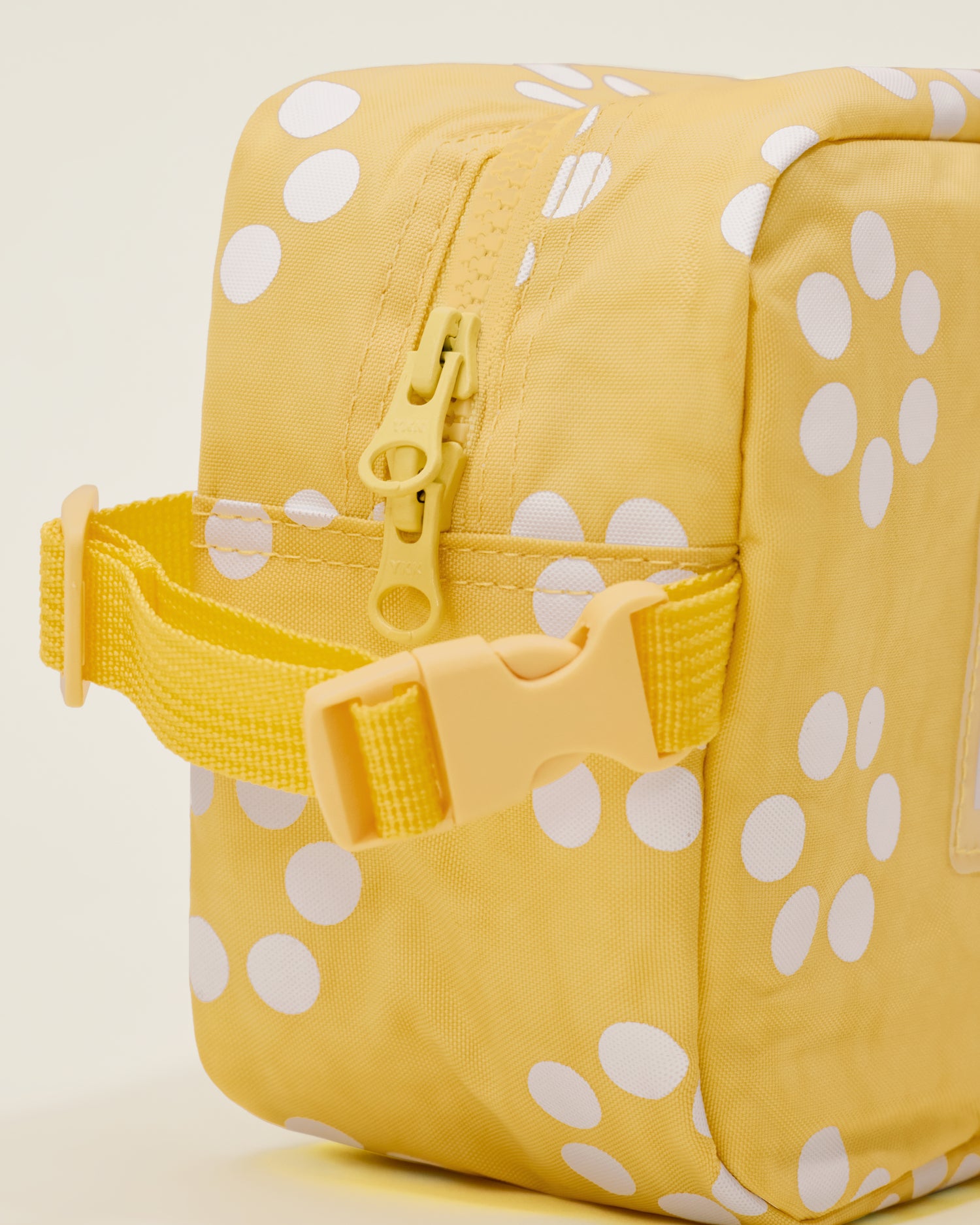 Close up of the Mini Cooler Bag in the Sunshine Dots print, showing a detail of a handle with a clasp