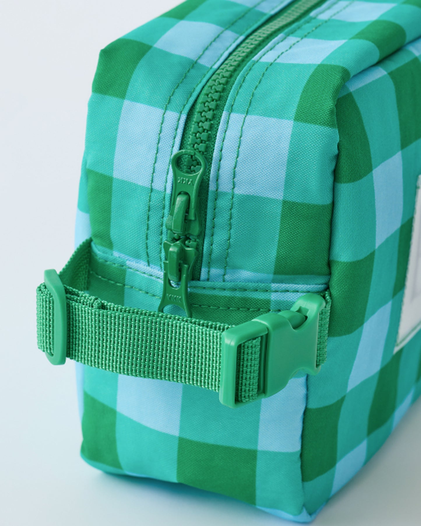 Close up of zipper and clips on the Mini Cooler Bag in Teal Gingham, on a beige background.
