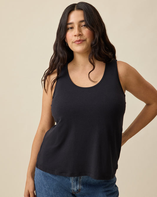 Model is wearing Modal Signature Nursing Tank in Black on a beige background. @model_info:Linda is wearing a Small.