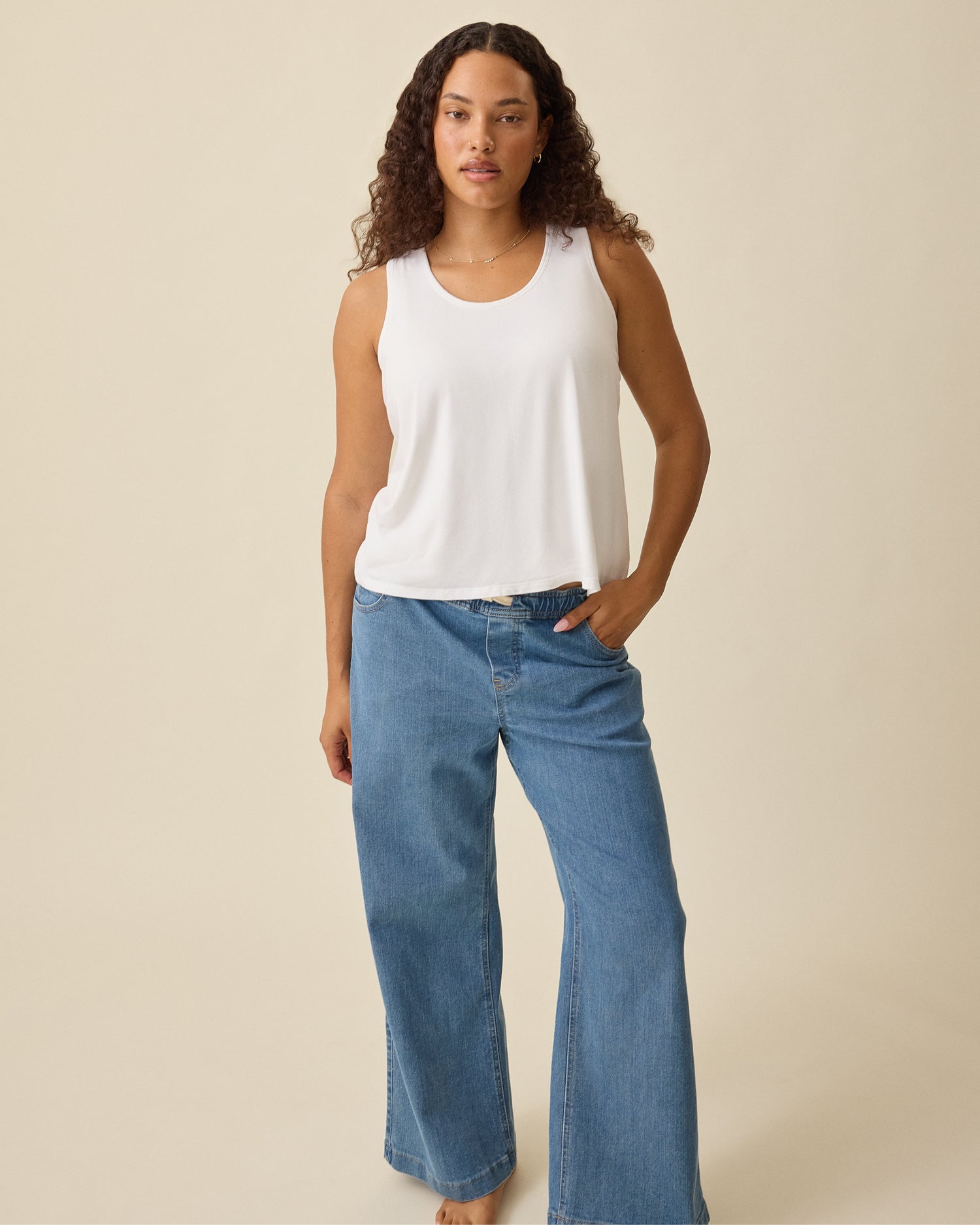 Model is wearing Modal Signature Nursing Tank in White on a beige background.