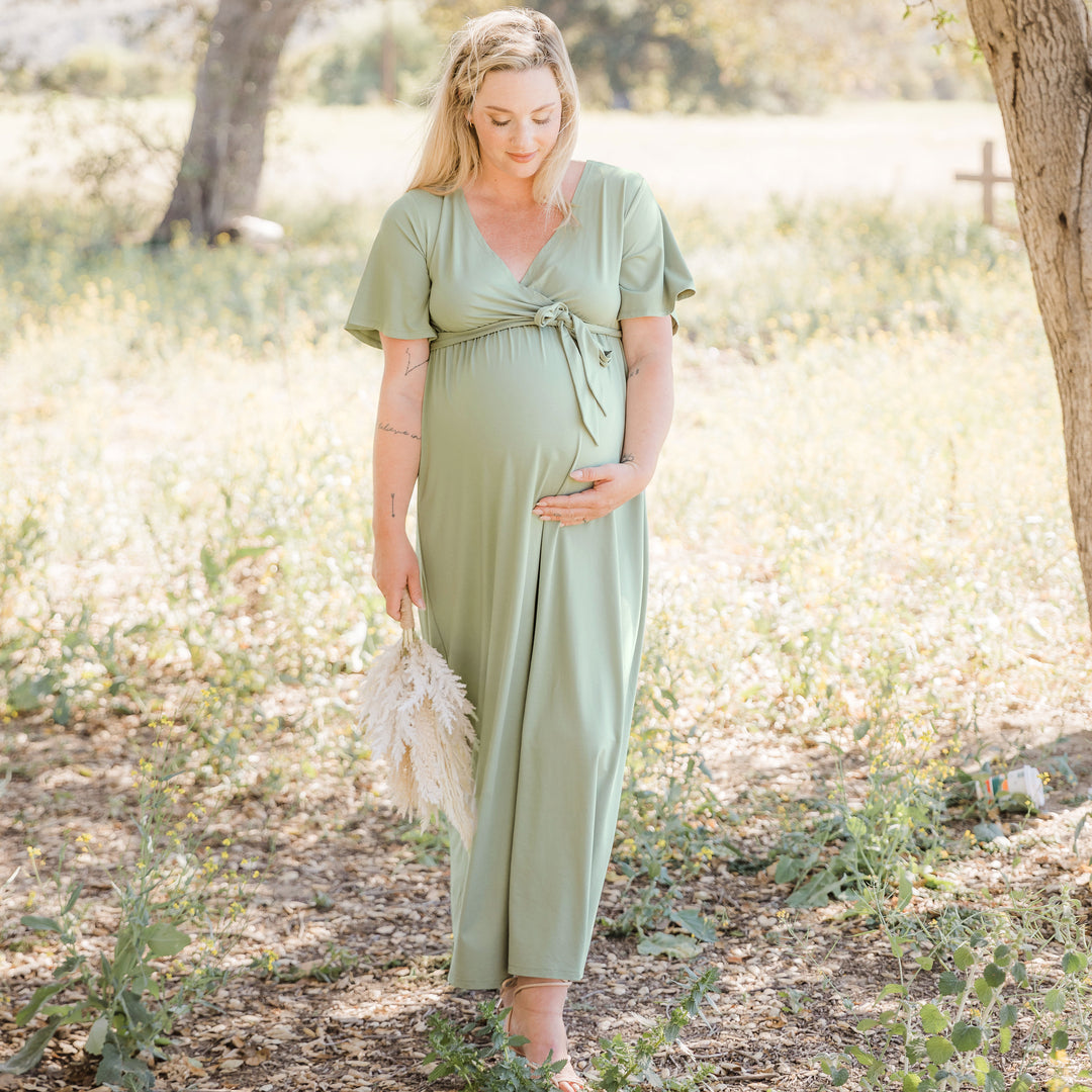 Model standing outside in the Wrap Maternity Maxi Dress in Rosemary.@model_info:Caitlin is wearing a Medium. 
