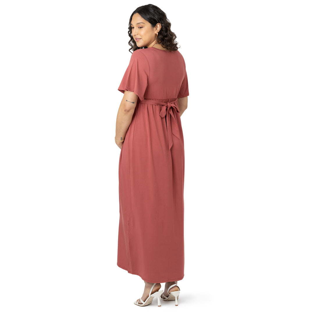 Three quarters view of a model wearing the Wrap Maternity Maxi Dress in Terracotta. 