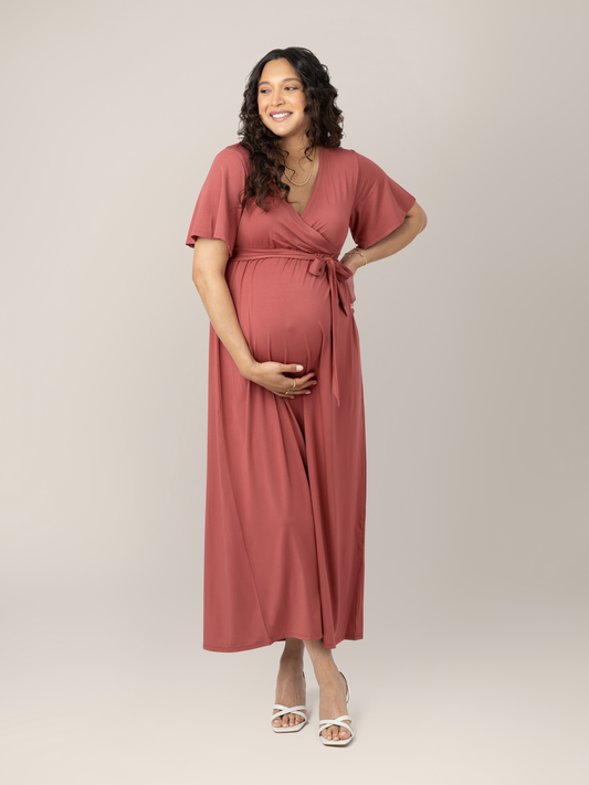 Model wearing the Wrap Maternity Maxi Dress in Terracotta with her hand on her baby bump. @model_info:BreAuna is wearing a Medium.
