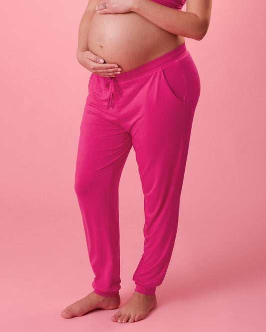 Front view of model wearing Ultralight Sleep & Lounge Jogger in Raspberry Pink on a pink background@model_info:Megan is 5'9" and wearing a Medium Long.