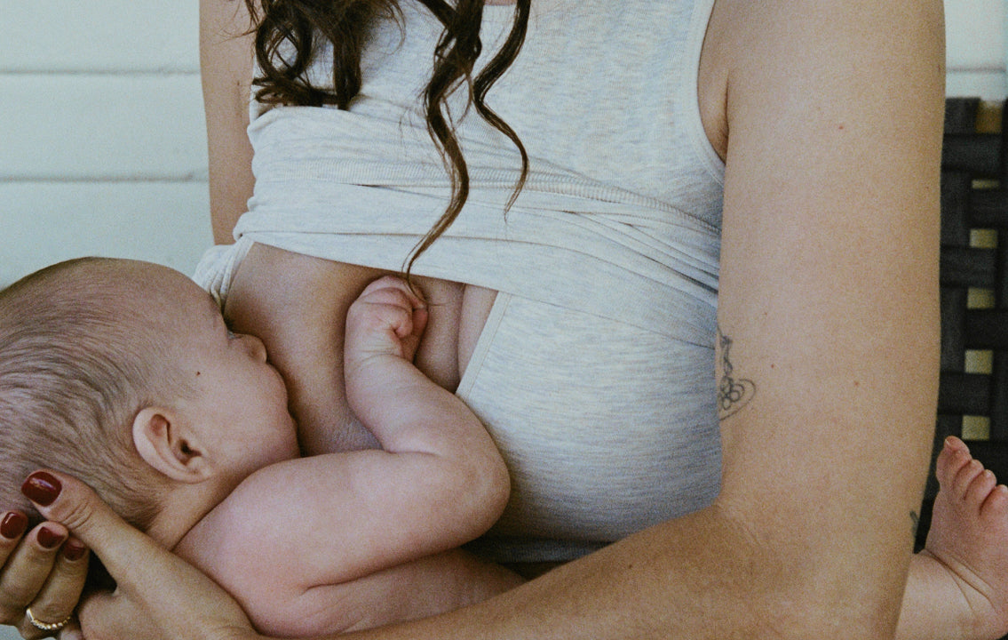 Mother breastfeeding baby while wearing Sublime® Bamboo Hands-Free Pumping Longline Bra Top in Oatmeal Heather