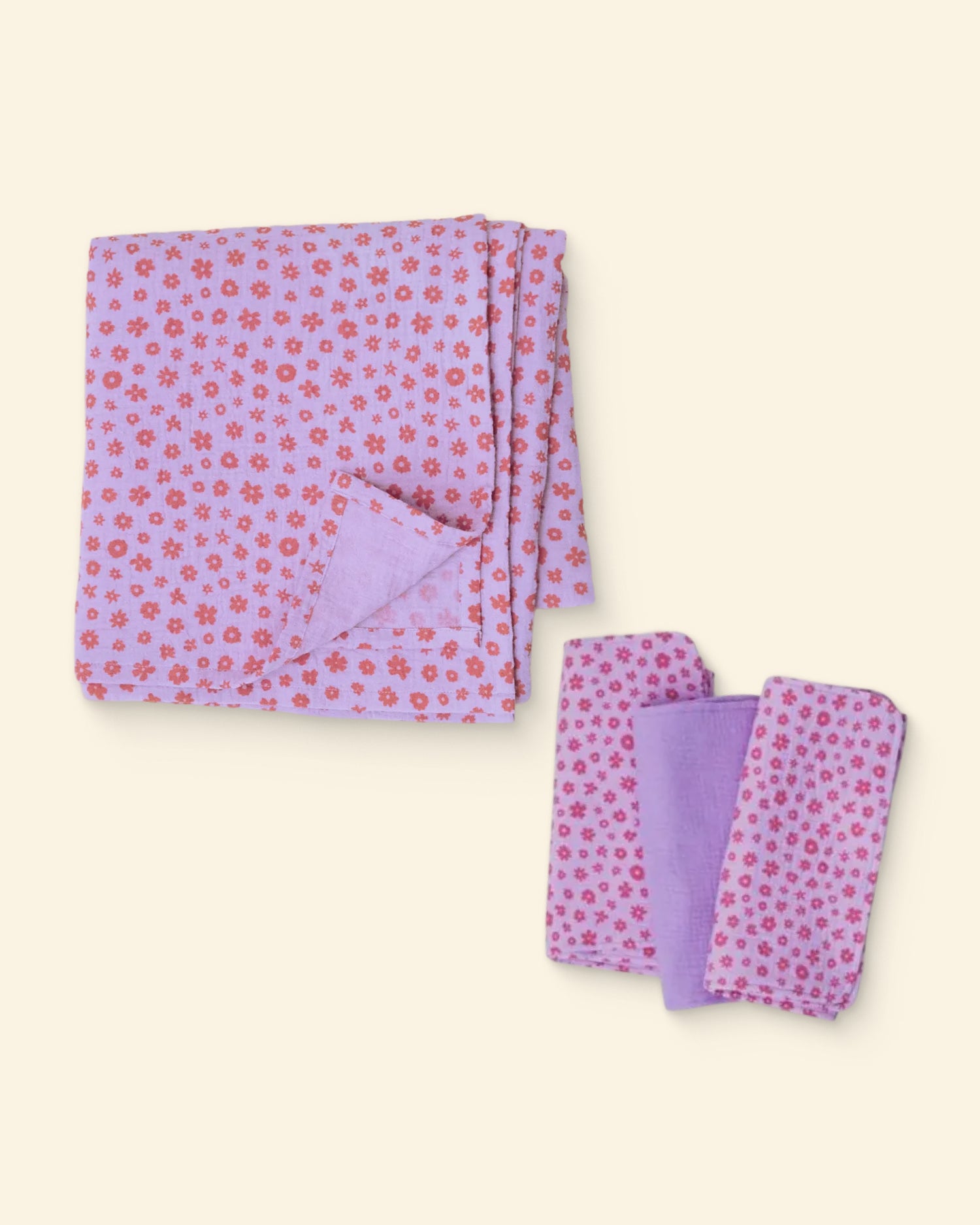 Set of lavender floral patterned burp cloths and swaddle on a light background