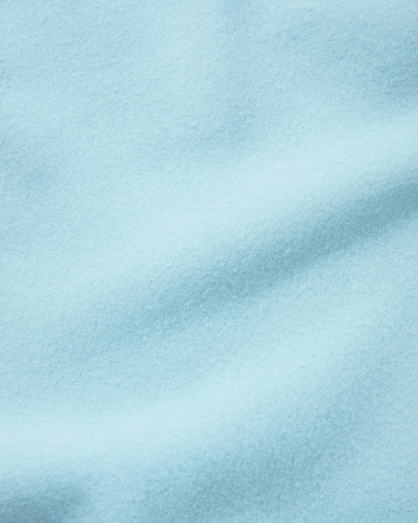 Close up of the soft light blue fleece blanket of the Nap Mat in Green Stripe.