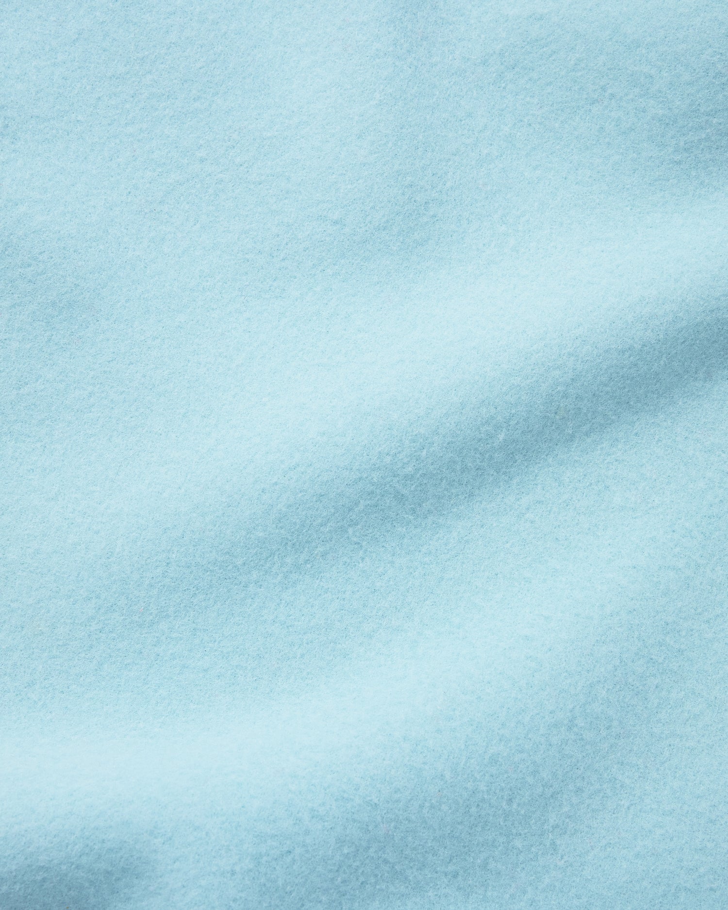 Close up of the soft light blue fleece blanket of the Nap Mat in Green Stripe.