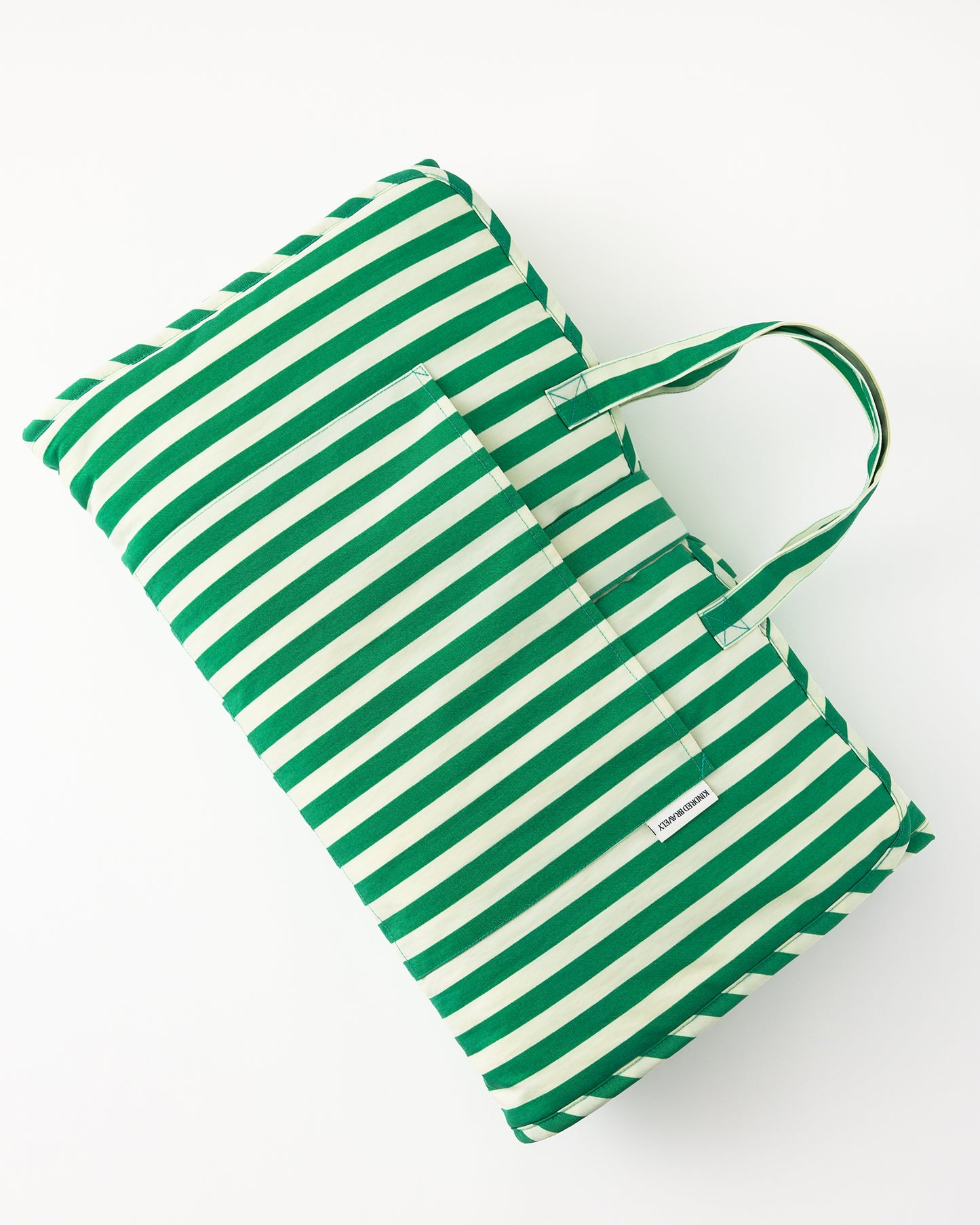 Nap Mat in Green Stripe, easily folded to display pocket for lovey and ready to go, on a white background.