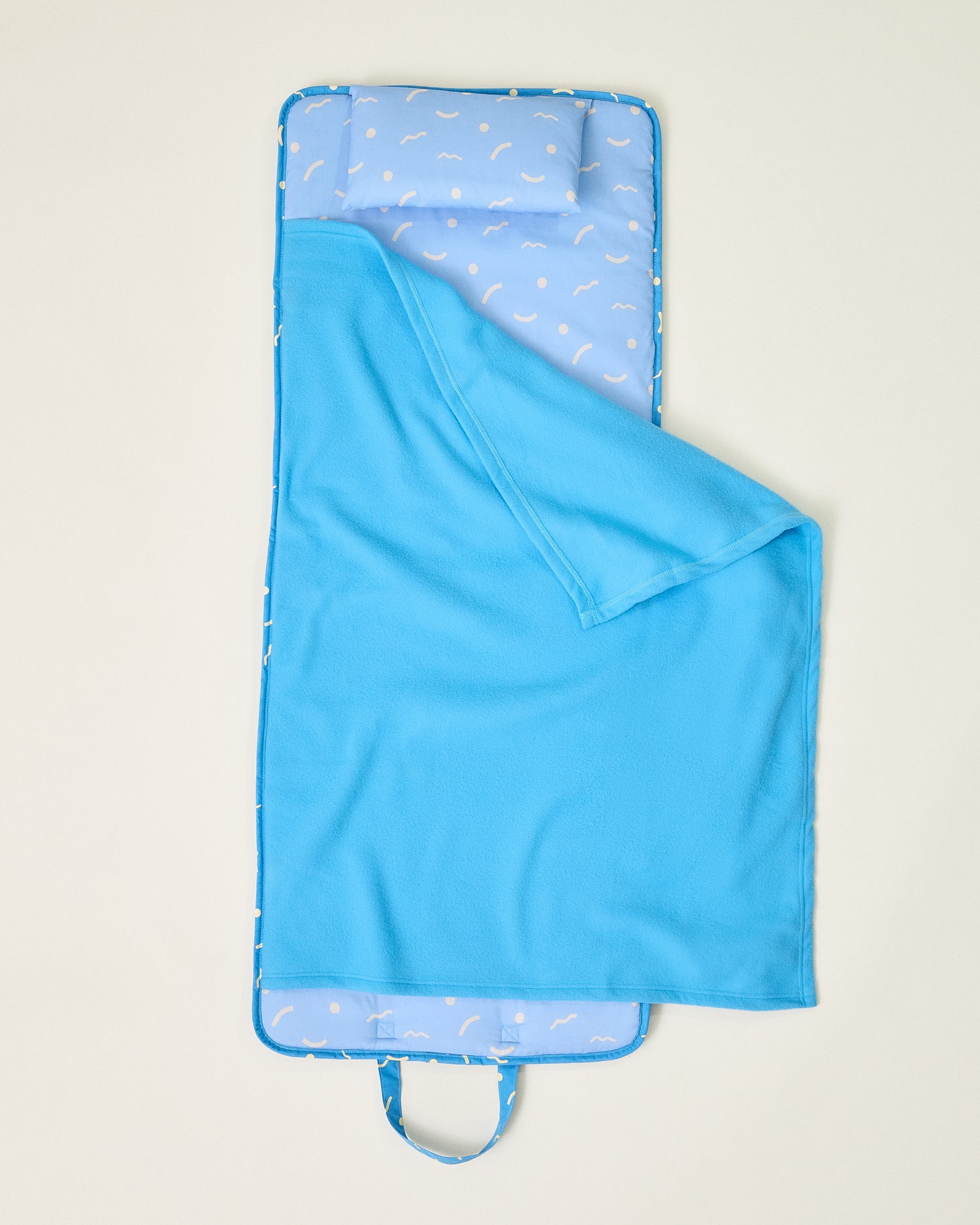 Opened Nap Mat in solid blue and sky squiggles pattern on beige background
