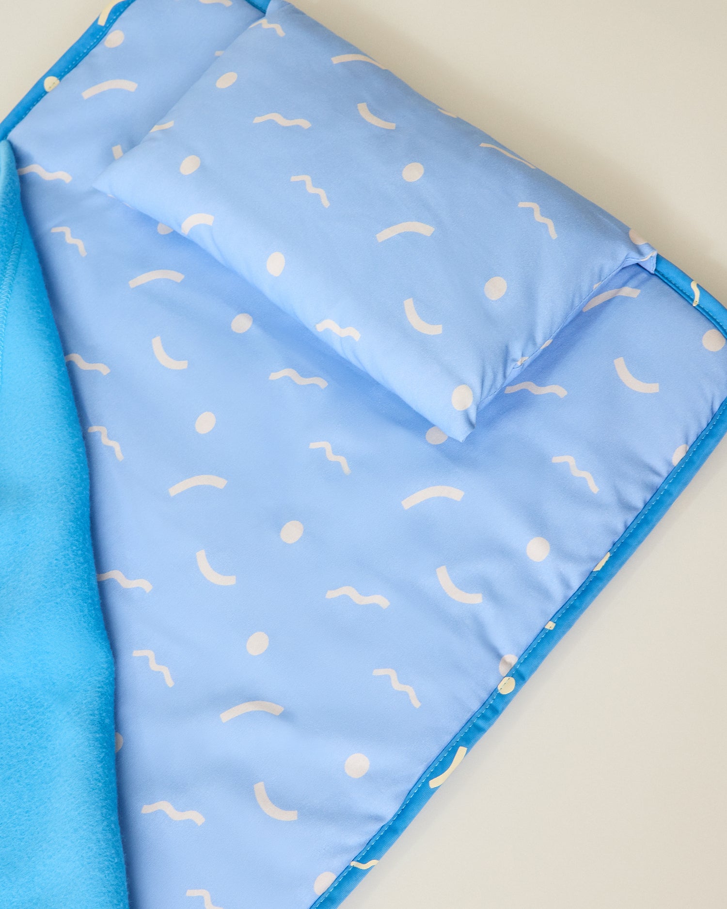 Nap Mat in and sky squiggles pattern with matching pillow on beige background