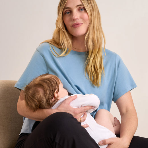 Woman in a blue t-shirt nursing a baby
