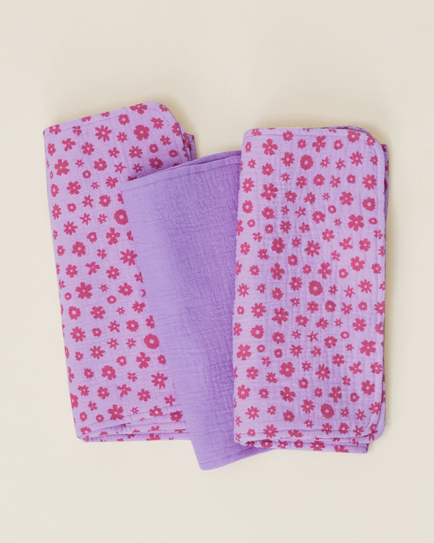 A set of Organic Muslin Burp Cloth in the Lavender Cosmos print, folded neatly and displayed on a plain surface.