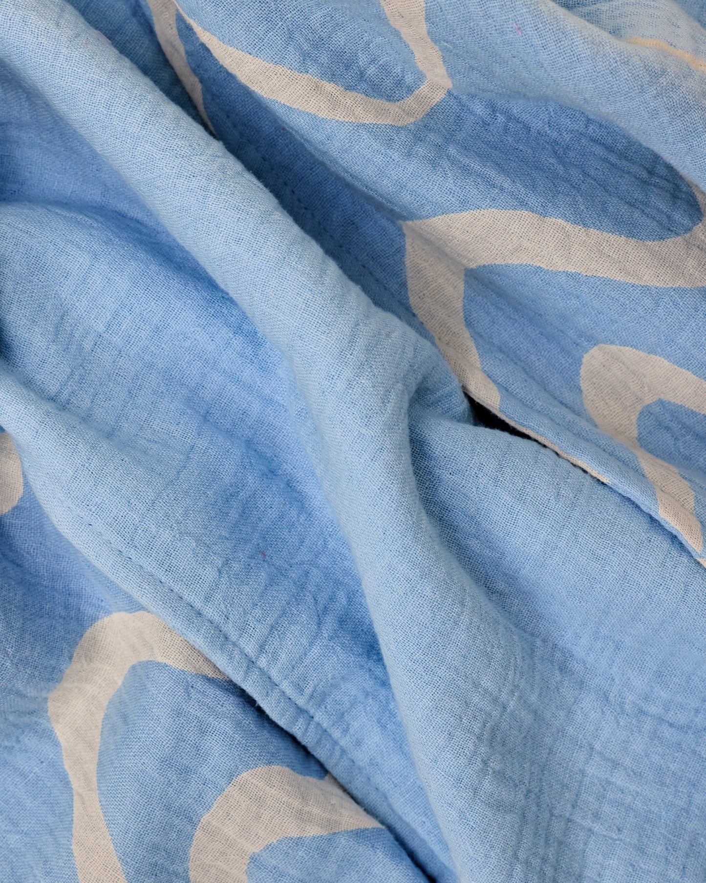 Close up of the set Organic Muslin Burp Cloth in Blue Waves print.