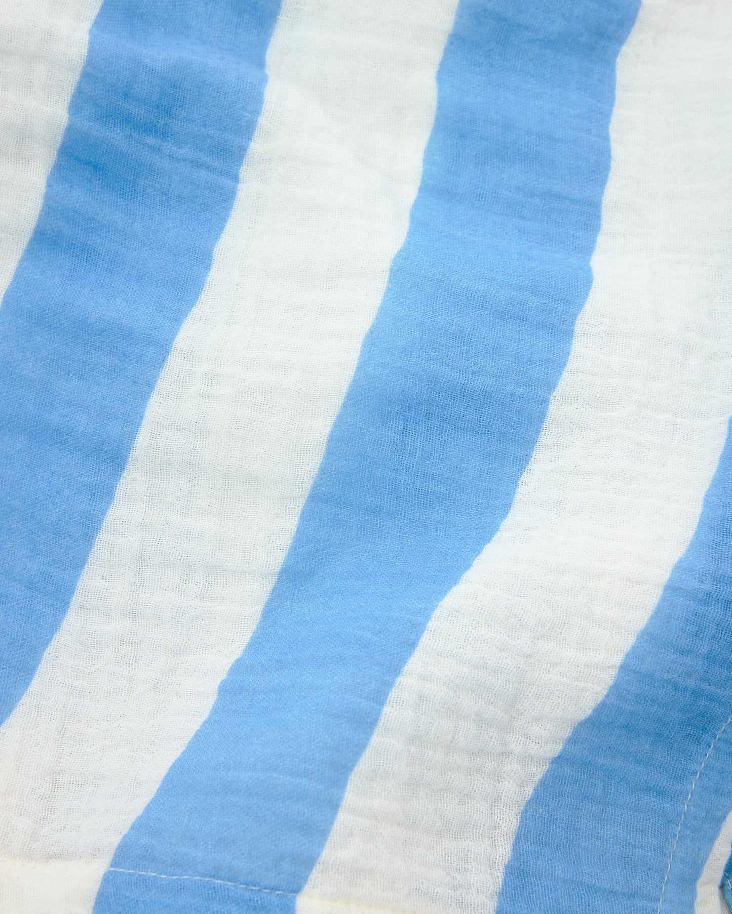 Close up of material on Organic Muslin Burp Cloth (Three-Pack) in Blue Wide Stripe. 