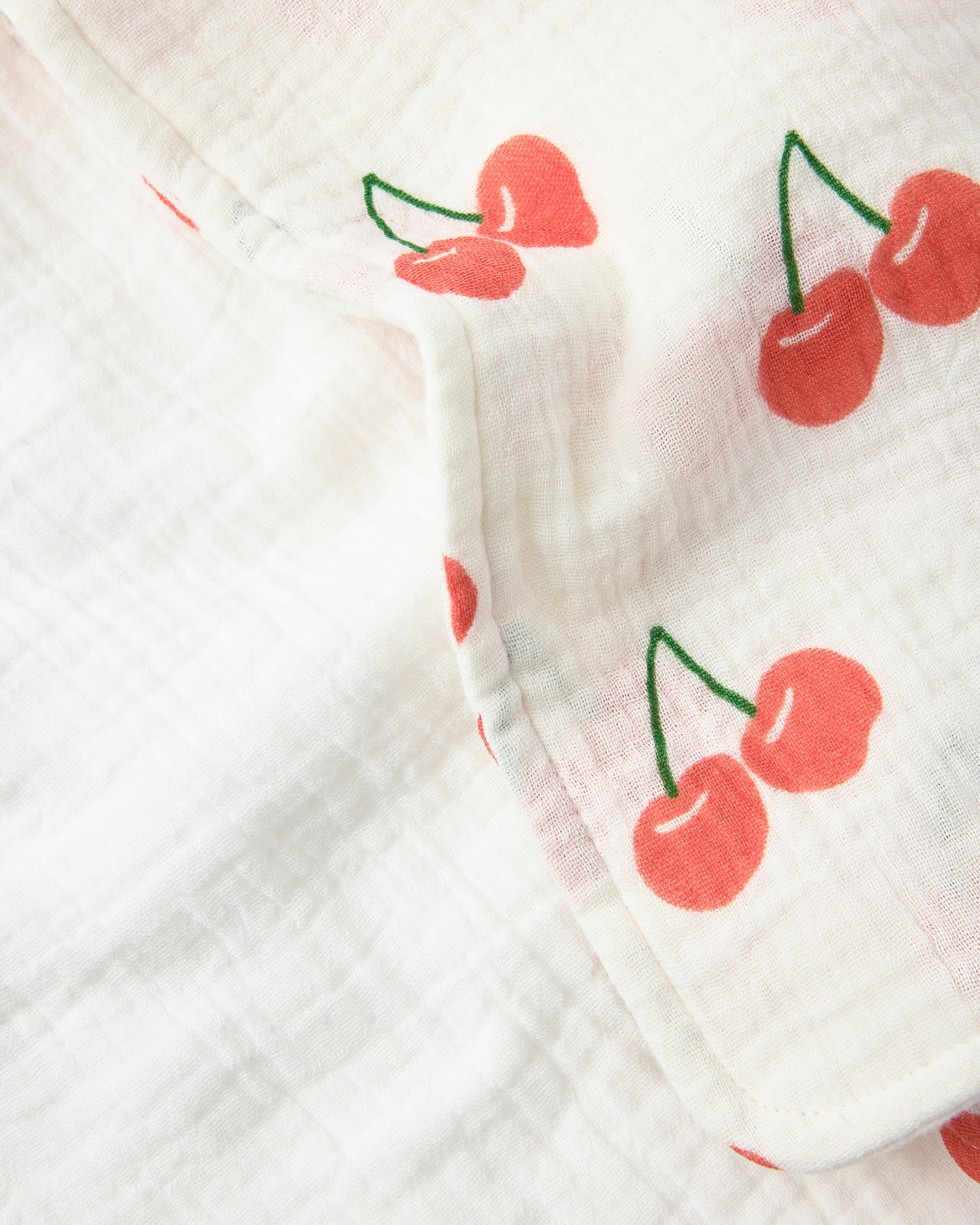 Close up of the Organic Muslin Burp Cloth (3-Pack) in White Cherries on a white background.