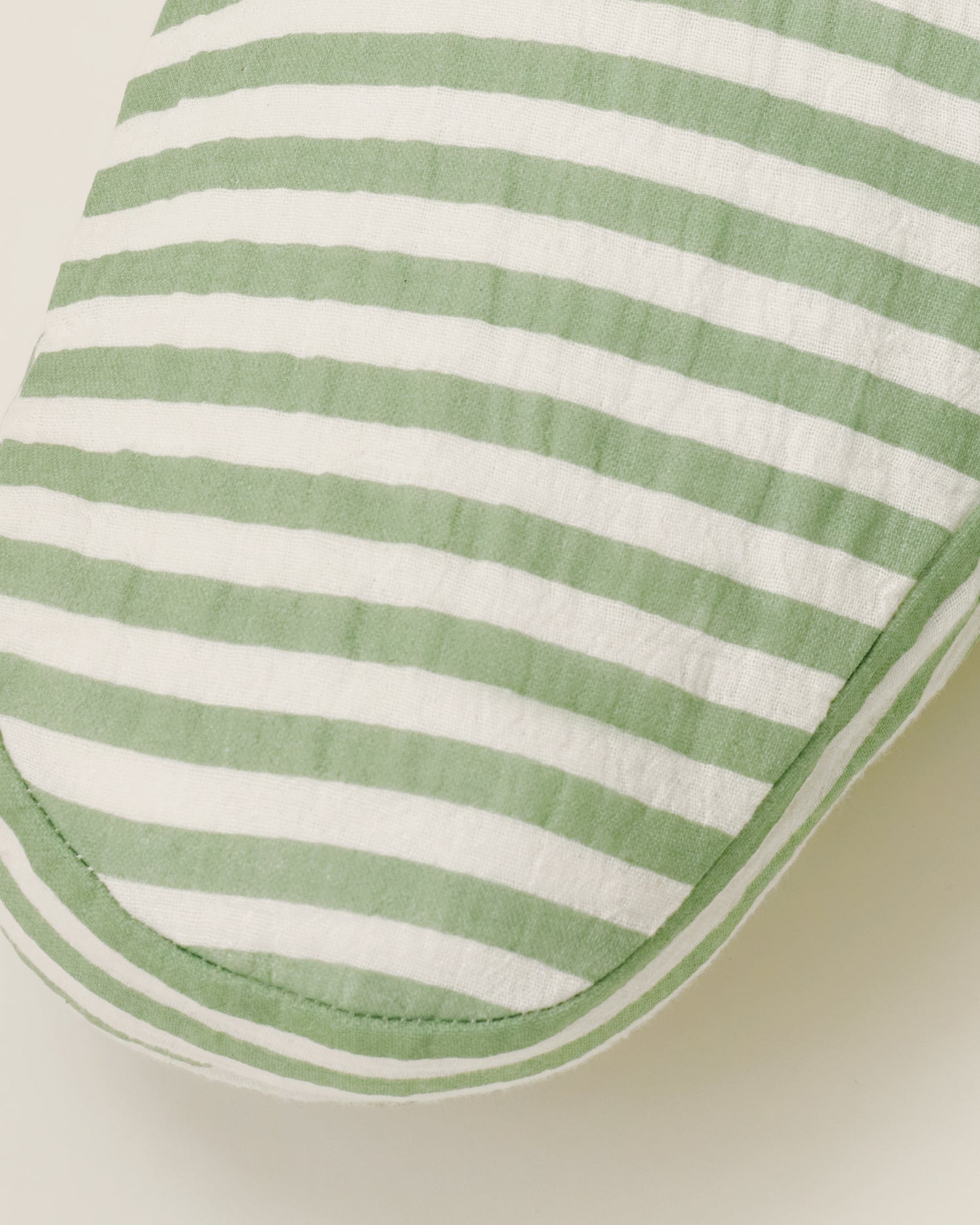 Close up of the Organic Muslin Nursing Pillow Cover in the Sage Stripe print