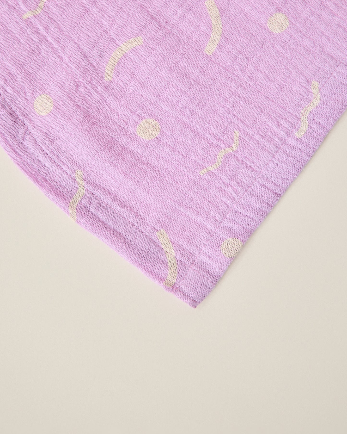 Purple lilac squiggles fabric on a beige background