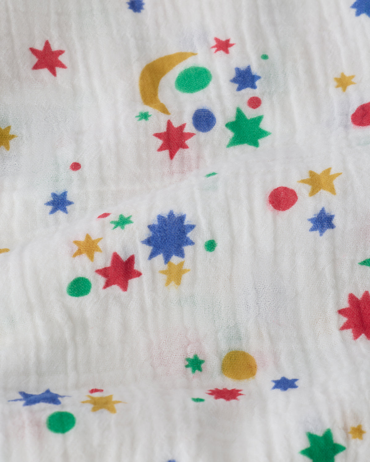 Close up of the Organic Muslin Swaddle in White Starry Sky pattern. 